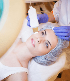 Косметолог проводит чистку лица при помощи ультразвукового аппарата